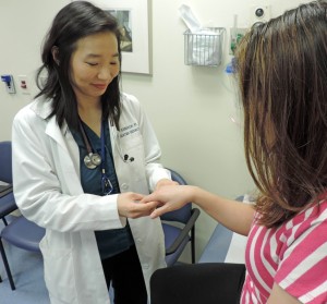 Photo of a doctor examining a patient's hand.