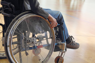 Photo showing a person's legs as he sits in a wheelchair.