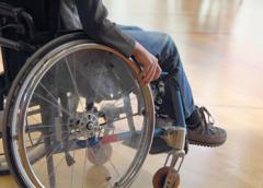 Photo showing a person's legs as he sits in a wheelchair.
