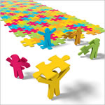 colored people placing color puzzle pieces down
